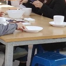 흰 그릇과 접시 앞에서 붓을 든 손