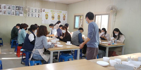 도자기 원데이 클래스 — 교실 탁자에 둘러앉아 흰 그릇과 컵에 그림을 그리는 체험자들, 벽에 «전통도자기 제작과정» 게시물